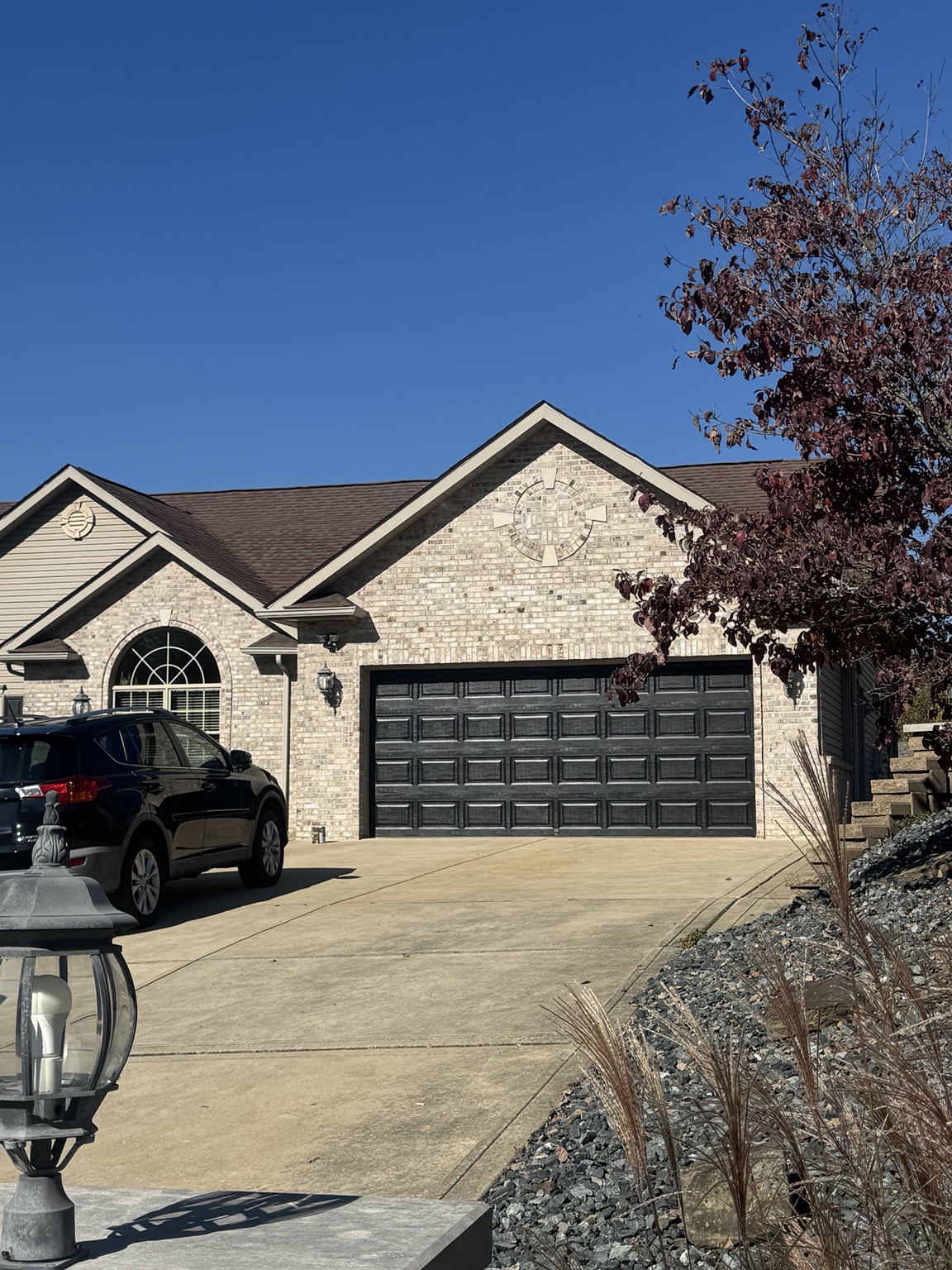 Finished black garage door on a brick home exterior
